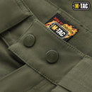 Close-up of olive green M-TAC Army style Bermuda shorts featuring durable buttons and branded label detail.
