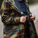 Close-up of a person wearing an original Belgian military waterproof jigsaw camouflage raincoat with hood and zipper detail