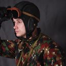 Man wearing Swiss Alpenflage camouflage military coveralls and vintage black leather pilot helmet with goggles raised