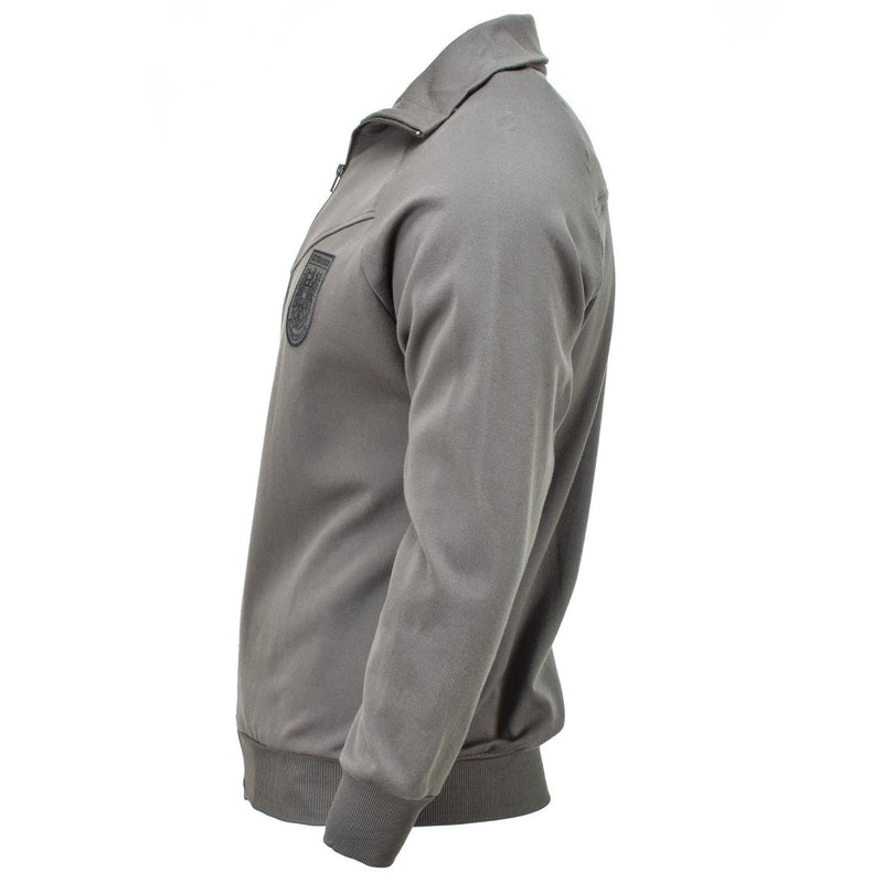 Side view of genuine Austrian Army grey sports jacket with long sleeves and zippered front on white background