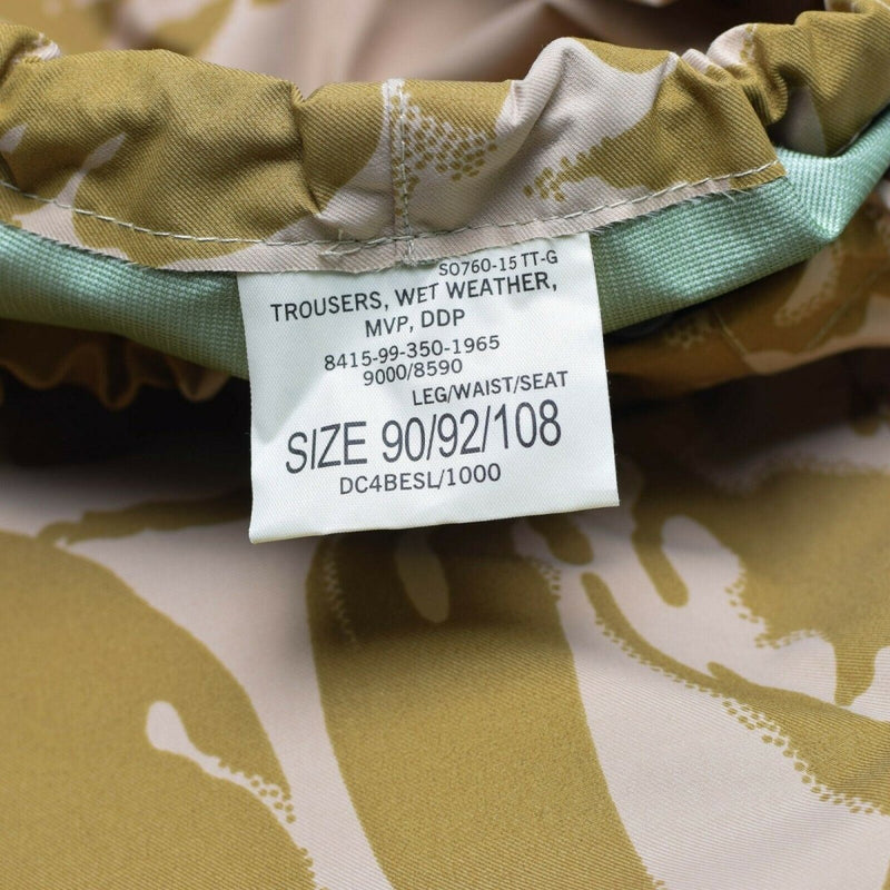 Close-up of size label on British army desert camouflage waterproof combat trousers for wet weather use
