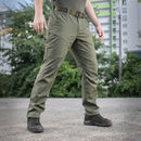 Man wearing olive green M-TAC military tactical pants with cargo pockets and black boots outdoors