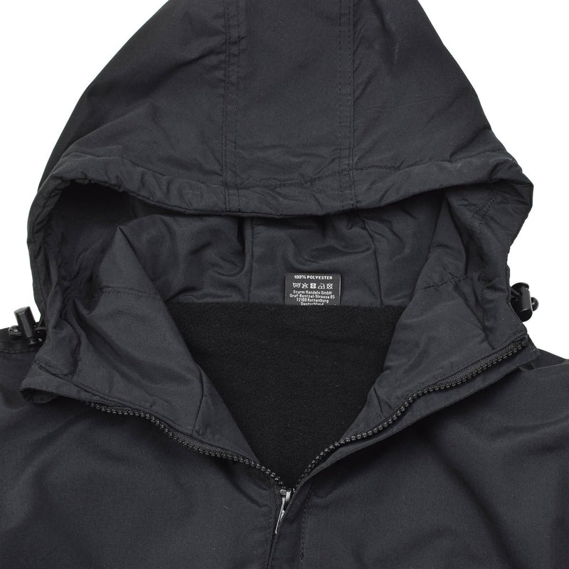 Close-up of black MIL-TEC German military jacket with windproof hood and soft fleece lining inside