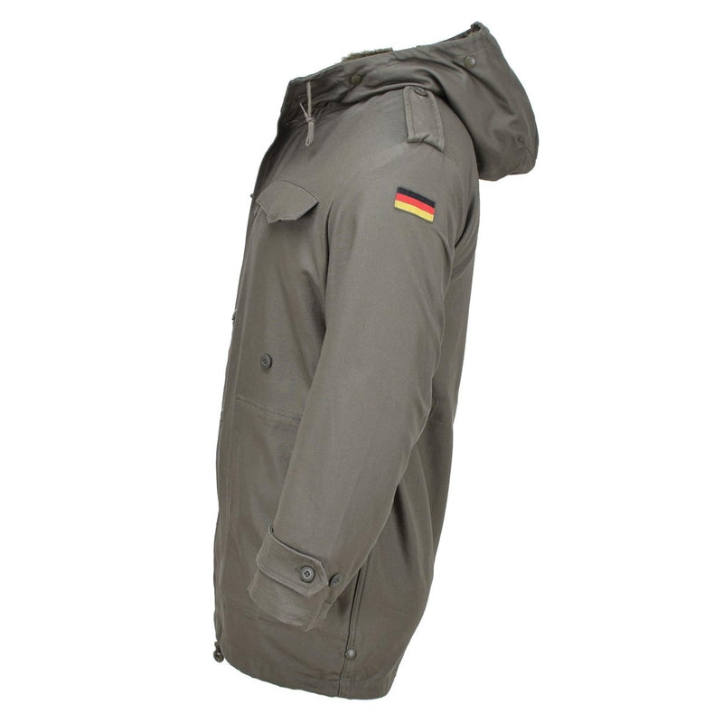 Side view of olive green MIL-TEC German military style parka with hood, storm flap, and German flag patch on sleeve.