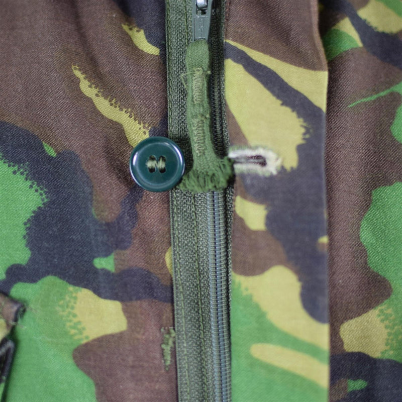 Close-up of a woodland camo British army BDU combat smock jacket with zipper and button storm flap detail
