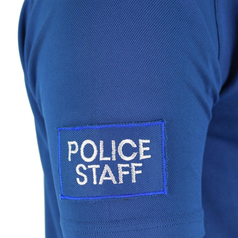 Close-up of blue breathable police staff t-shirt sleeve with embroidered patch on lightweight fabric