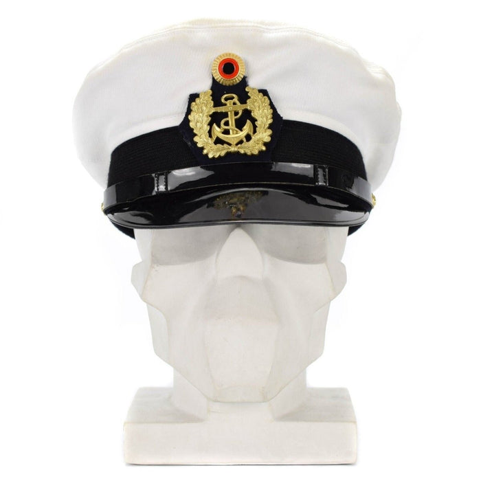 Gorra blanca de oficial de la Armada alemana con visera, insignia dorada y visera negra sobre una cabeza de maniquí blanca.