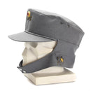 Original German Army Gebirgsjäger mountain cap grey with neck flap and floral badge on display mannequin head