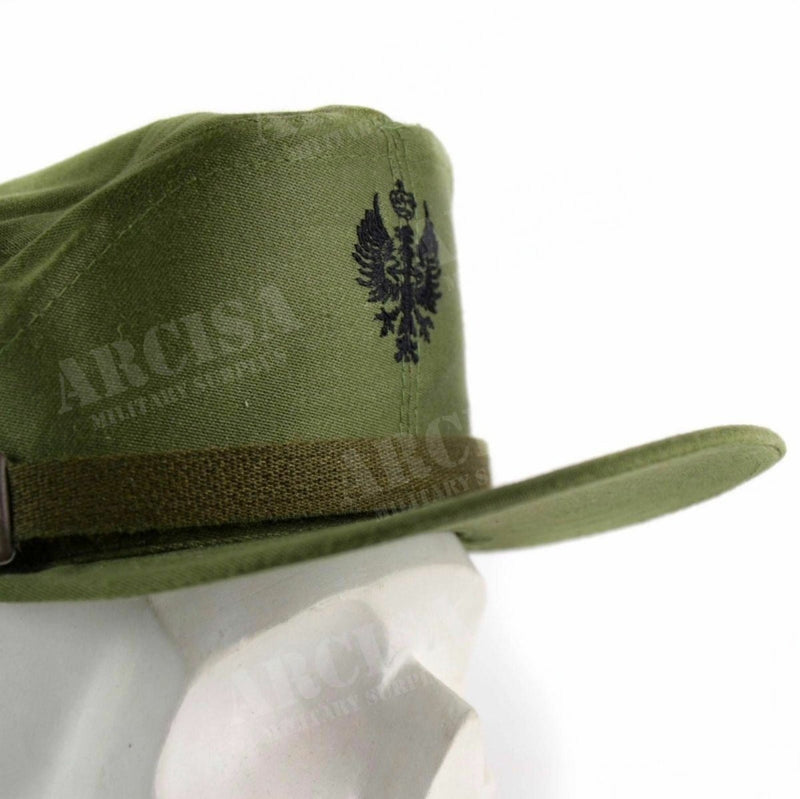 Olive green Spanish military visor cap with black emblem and adjustable chin strap on white mannequin head