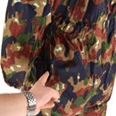 Close-up of a hand opening a zipper on Swiss army Alpenflage camouflage coverall pocket.