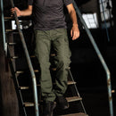 Man wearing olive green Pentagon BDU 2.0 combat cargo pants with reinforced knees and multiple pockets on metal stairs
