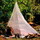Mosquito net set up outdoors with camping gear on a grassy area.