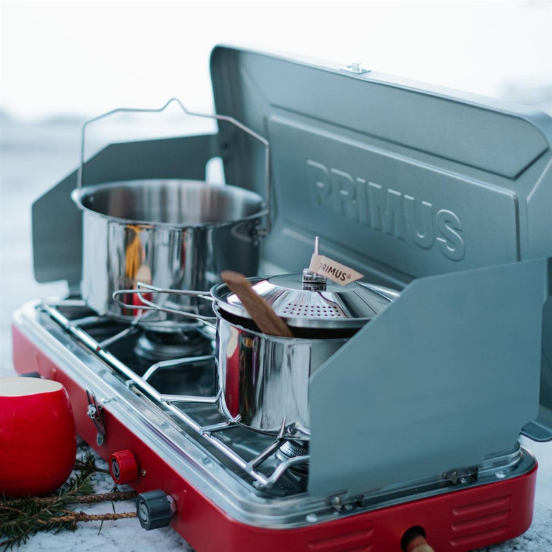 Primus Atle II portable dual burner camping stove with cooking pots and wind shields outdoors