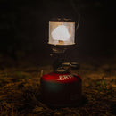 Primus Micron gas lamp lantern glowing with adjustable brightness on red fuel canister outdoors at night
